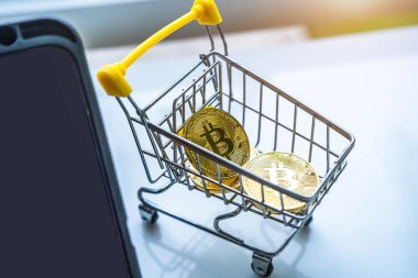 Altın bitcoin ya da kripto para ya da alışveriş arabasındaki semboller ve beyaz masadaki tablet yakın plan. Gelecek para birimi kavramı.
