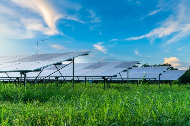 Fotovoltaik güneş enerjisi paneli dramatik gün batımı mavi gökyüzü arkaplanı, yeşil temiz Alternatif enerji kavramı.