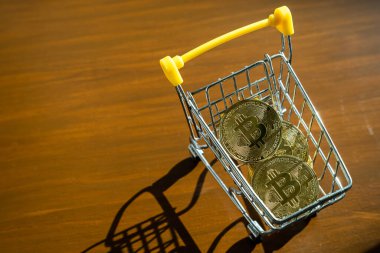 Altın bitcoin ya da kripto para ya da alışveriş arabasındaki sembollerin yakın çekimi. Gelecek para birimi kavramı.