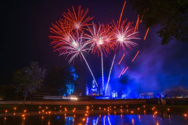 Güzel Havai fişek sahnesinin hafif rengi Sukhothai Co Lamplighter Loy Krathong Festivali 'nin Sukhothai Tarihi Tapınak Parkı' ndaki partisi Sukhothai 'nin kalıntılarını kapsıyor.. 