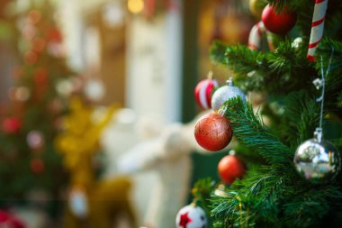 Mutlu Noel 'ler, renkli baloları, hediye kutusunu ve Noel kutlaması paketini kapatın, Noel ve Yeni Yıl boyunca Yeşil Noel ağacı arka planında çan süslemesi.