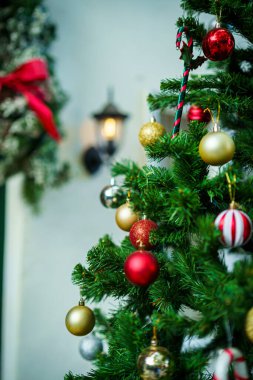 Mutlu Noel 'ler, renkli baloları, hediye kutusunu ve Noel kutlaması paketini kapatın, Noel ve Yeni Yıl boyunca Yeşil Noel ağacı arka planında çan süslemesi.