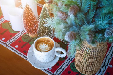 Sıcak kahveli latte ile sütlü sütlü sütlü bardakta Xmas dekorları ve ahşap masa üzerindeki Xmas ağacı süslemeleri Mutlu Noeller ve yeni yılı kutluyoruz..