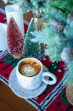 Sıcak kahveli latte ile sütlü sütlü sütlü bardakta Xmas dekorları ve ahşap masa üzerindeki Xmas ağacı süslemeleri Mutlu Noeller ve yeni yılı kutluyoruz..