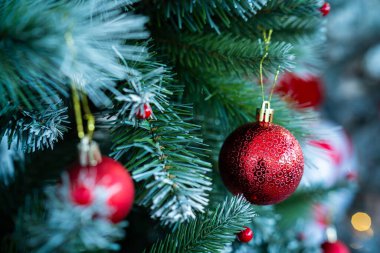 Mutlu Noel 'ler, renkli baloları, hediye kutusunu ve Noel kutlaması paketini kapatın, Noel ve Yeni Yıl boyunca Yeşil Noel ağacı arka planında çan süslemesi.