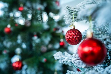 Mutlu Noel 'ler, renkli baloları, hediye kutusunu ve Noel kutlaması paketini kapatın, Noel ve Yeni Yıl boyunca Yeşil Noel ağacı arka planında çan süslemesi.