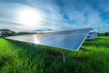 Fotovoltaik güneş enerjisi paneli dramatik gün batımı mavi gökyüzü arkaplanı, yeşil temiz Alternatif enerji kavramı.