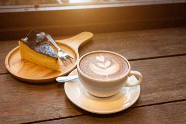 Sütlü sütlü sütlü sütlü sütlü sıcak kahve ve ahşap masanın üstünde ev yapımı çikolatalı kek ahşap masa. İş konsepti sırasında bir kafede kahvaltı olarak.