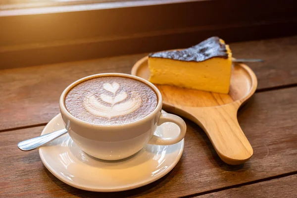 Sütlü sütlü sütlü sütlü sütlü sıcak kahve ve ahşap masanın üstünde ev yapımı çikolatalı kek ahşap masa. İş konsepti sırasında bir kafede kahvaltı olarak.