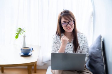 Asyalı serbest iş adamlarının mutlu başarılı işleri iş kadınları kahve fincanı ve akıllı telefonla dizüstü bilgisayarla çalışma cesaretini dile getirdi.