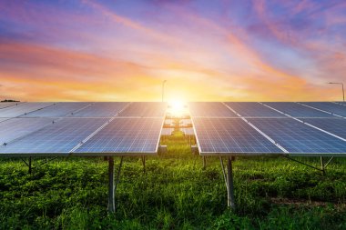 Fotovoltaik modüller güneş enerjisi santrali dramatik gün batımı arka planı, temiz alternatif enerji konsepti.