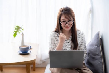 Asyalı serbest iş adamlarının mutlu başarılı işleri iş kadınları kahve fincanı ve akıllı telefonla dizüstü bilgisayarla çalışma cesaretini dile getirdi.