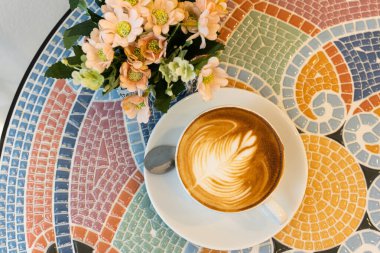 Kahveli sütlü sütlü sütlü sütlü sütlü kahve mermer zemin masasında kahvaltım kafede, iş konsepti sırasında.