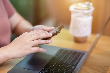 Ellerinizi yakın tutun, serbest çalışan iş kadınları akıllı telefondan yazı yazıyorlar. Laptop bilgisayar ve kahve fincanı ile çalışıyorlar. İş hayatı tarzı iletişim konsepti.