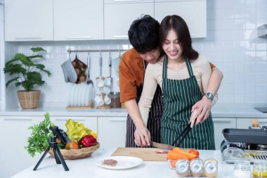 Genç Asya Akıntısı 'nı mobil olarak sevmekten, neşeli bir şekilde yemek pişirmekten, sebze, et, ekmek pişirmekten keyif almaktan, hem de bir apartman dairesinde hem de evde ayakta dururken.