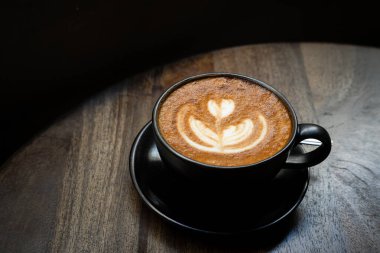 Sütlü sütlü sütlü sütlü sıcak kahve fincanı ahşap masanın üstünde. Kafedeki bir kafede kahvaltı olarak, iş konsepti sırasında, klasik tarzda.