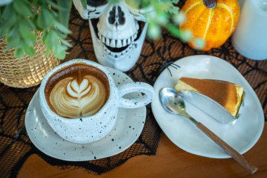 Sütlü sütlü sütlü sütlü sütlü sıcak kahve ve kahveli ev yapımı cheesecake. Cadılar Bayramı Cadılar Bayramı Cadılar Bayramı arkaplanda Cadılar Bayramı teması..