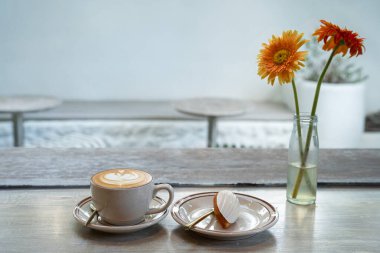 Sütlü sütlü sütlü sütlü sütlü sıcak kahve ve ahşap masanın üstünde ev yapımı çikolatalı kurabiyeler. Kafedeki bir kafede kahvaltı olarak, iş sırasında..