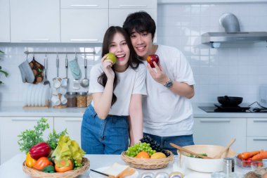 Mutlu Aile portresi, neşeli bir yemek hazırlayan neşeli bir Asyalı 'nın mutlu aile portresi. Mutfakta, et, ekmek ve sebzelerle yemek pişirmekten keyif alıyor.