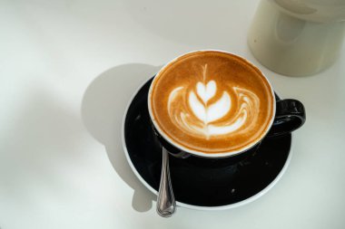 Sütlü sütlü sütlü sütlü sıcak kahve fincanı ahşap masanın üstünde. Kafedeki bir kafede kahvaltı olarak, iş konsepti sırasında, klasik tarzda.