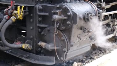 Buharlı tren motorunun detaylı görüntüsü. Siyah tren kompozisyonu, istasyonda bekliyor. 4K