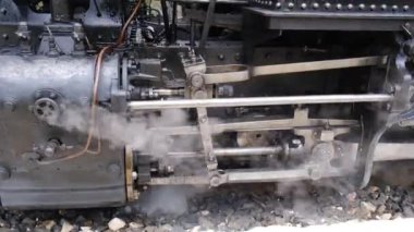 Buharlı tren motorunun detaylı görüntüsü. Siyah tren kompozisyonu, istasyonda bekliyor. 4K