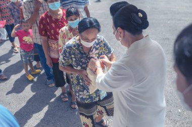 Chiangmai, Tayland - 7 Ağustos 2022: Hayırseverler ve gönüllüler fakir ve aç köylülere pirinç, kuru yiyecek ve para bağışlamak için gelirler.