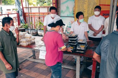 Chiangmai, Tayland - 30 Eylül 2022: Fakir ve aç olanlar gönüllülerden yıllık vejetaryen festivali için bedava yemek almak için sıraya girdiler: gıda bağışı kavramı