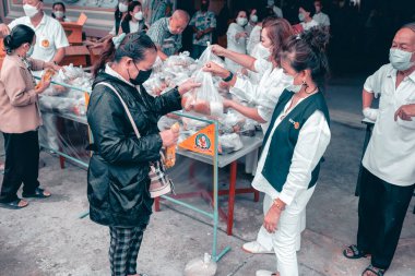 Chiangmai, Tayland - 30 Eylül 2022: Fakir ve aç olanlar gönüllülerden yıllık vejetaryen festivali için bedava yemek almak için sıraya girdiler: gıda bağışı kavramı