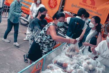 Chiangmai, Tayland - 30 Eylül 2022: Fakir ve aç olanlar gönüllülerden yıllık vejetaryen festivali için bedava yemek almak için sıraya girdiler: gıda bağışı kavramı