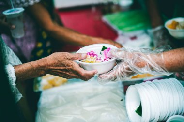 Gönüllülerden yardım isteyen fakir insanların elleri: gıda bağışı kavramı