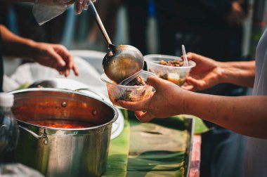 Gönüllüler fakirlere yemek veriyor, dilencilere yardım etmek için bedava yemek veriyorlar. yiyecek bağışı konsepti