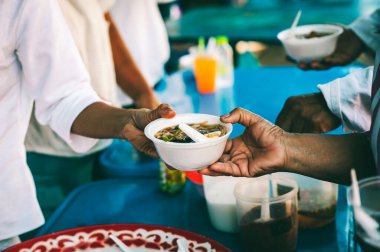 Gönüllüler fakirlere yemek veriyor, dilencilere yardım etmek için bedava yemek veriyorlar. yiyecek bağışı konsepti
