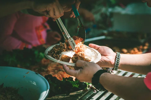 stock image Volunteers serving food for poor people : the concept of giving free food to beggars