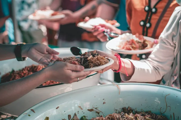 Volunteers offer free food to the poor: the concept of food sharing.