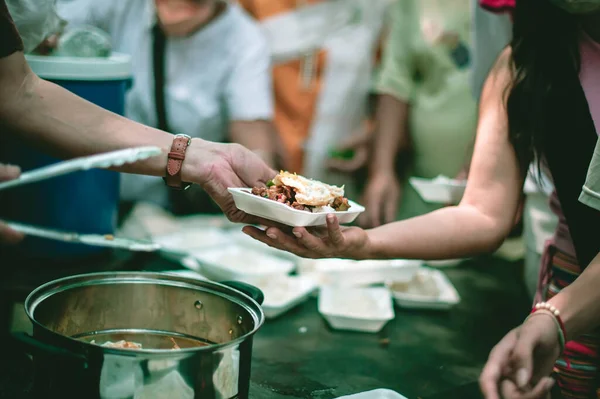 Volunteers offer free food to the poor: the concept of food sharing.