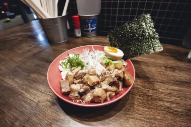 Haşlanmış yumurta ve yosun çarşaflı marine edilmiş domuz eti küpleri.