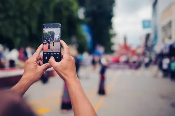 Lamphun, Tayland - 9 Eylül 2022: İnsanlar geçit töreninin fotoğraflarını ve videolarını çekmek için akıllı telefonları kullanıyor.