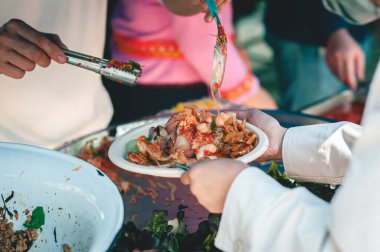 Aç ve fakirlere hazır yemek bağışlamak için gönüllü olmak.