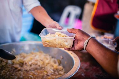 The hands of the poor apply for food from rich people who donate food.