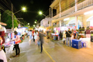 Bulanık insanlar gece pazarından alışveriş yapıyor.