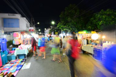Bulanık insanlar gece pazarından alışveriş yapıyor.