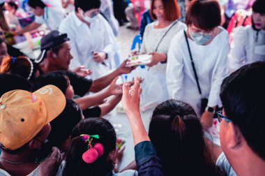 Chiang Mai - Tayland 25 Kasım 2023: Köylüler geleneksel yerel festivalde yiyecek dağıtan gönüllülerden bedava yemek almaya geliyorlar. Tayland 'ın Chiang Mai şehrinde.