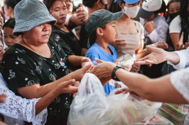Chiang Mai - Tayland 25 Kasım 2023: Köylüler geleneksel yerel festivalde yiyecek dağıtan gönüllülerden bedava yemek almaya geliyorlar. Tayland 'ın Chiang Mai şehrinde.