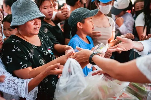 Chiang Mai - Tayland 25 Kasım 2023: Köylüler geleneksel yerel festivalde yiyecek dağıtan gönüllülerden bedava yemek almaya geliyorlar. Tayland 'ın Chiang Mai şehrinde.