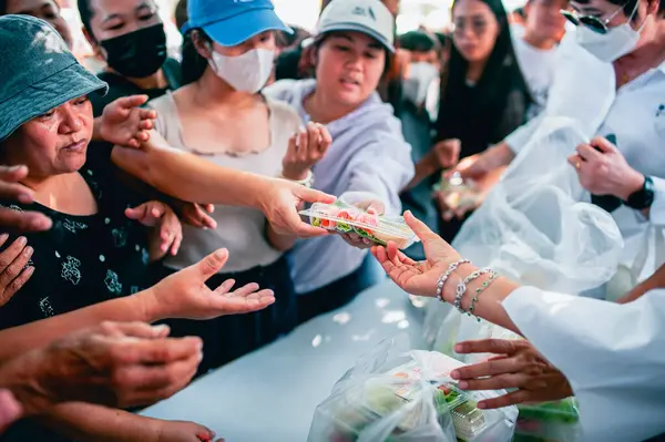 Chiang Mai - Tayland 25 Kasım 2023: Köylüler geleneksel yerel festivalde yiyecek dağıtan gönüllülerden bedava yemek almaya geliyorlar. Tayland 'ın Chiang Mai şehrinde.