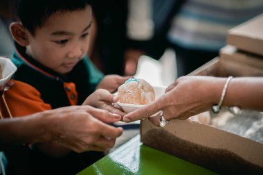 Chiang Mai - Tayland - 30 Ekim 2022: Köylüler ve çocuklar geleneksel yerel festivalde yiyecek dağıtan gönüllülerden bedava yemek almaya geliyorlar.