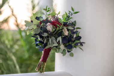 açık havada mavi ve yeşil yapraklı kırmızı, pembe ve beyaz buket.