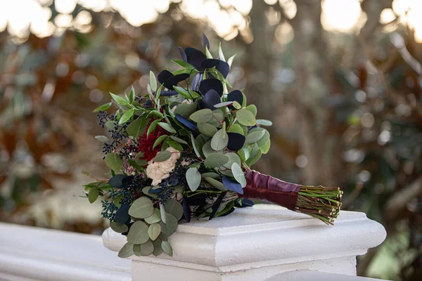 İnanılmaz kırmızı, pembe ve beyaz buket, açık havada mavi ve yeşil yapraklı.