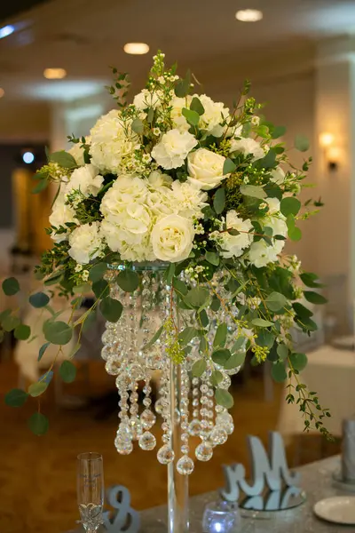 Beautiful bunch of white roses centerpiece with crystals at wedding reception